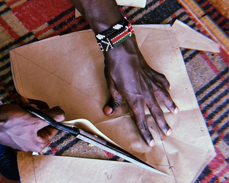 Hands cutting a pattern for an upcycled garment